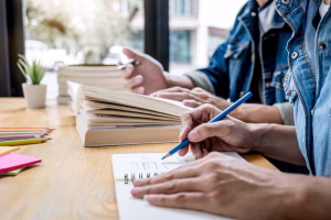 high school tutor college student group sitting desk library studying reading doing homework lesson practice preparing exam entrance education teaching learning concept 28283 1379